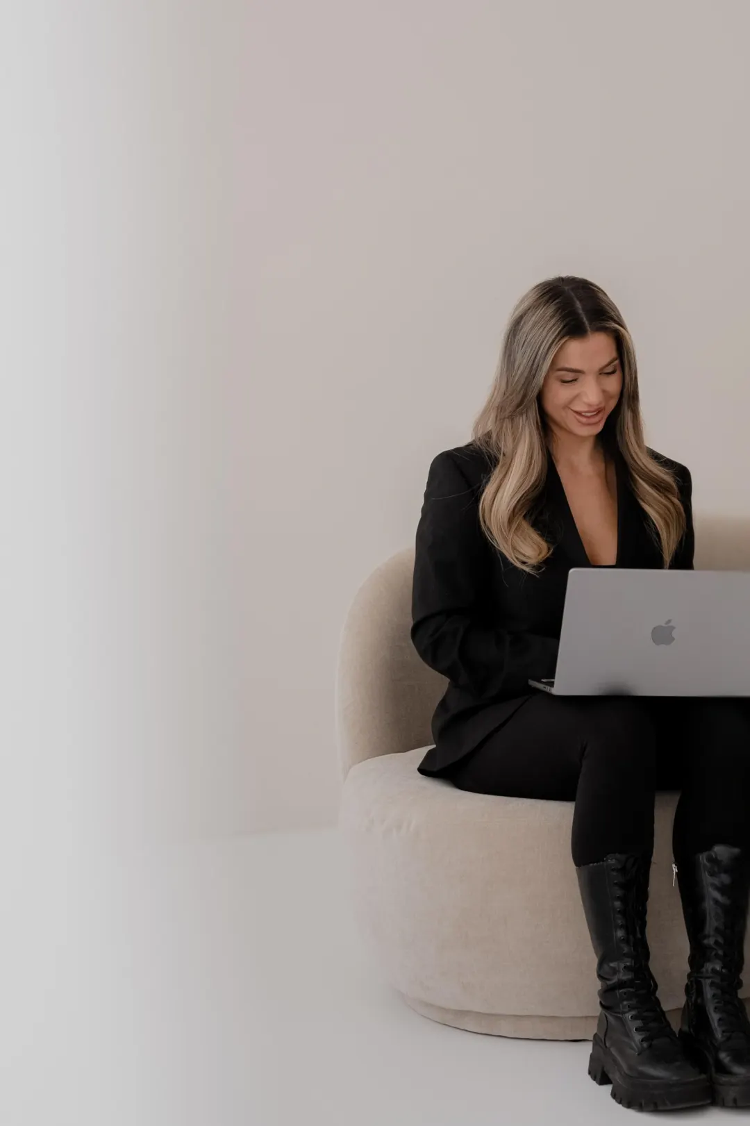 Emily Klatt lächelt beim Arbeiten am Laptop